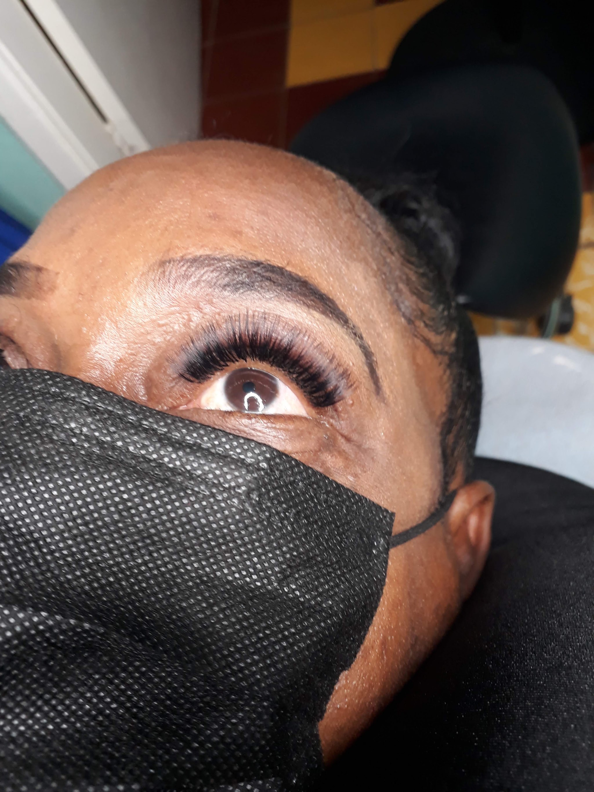 Klant met een nieuwe set wimperextensions, van boven gefotografeerd tijdens de behandeling